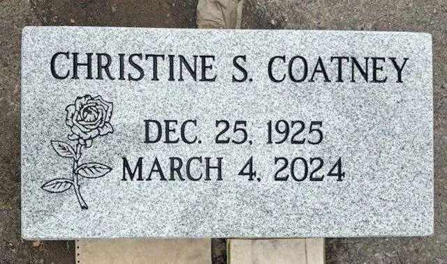 Gray granite flat marker with a carved rose